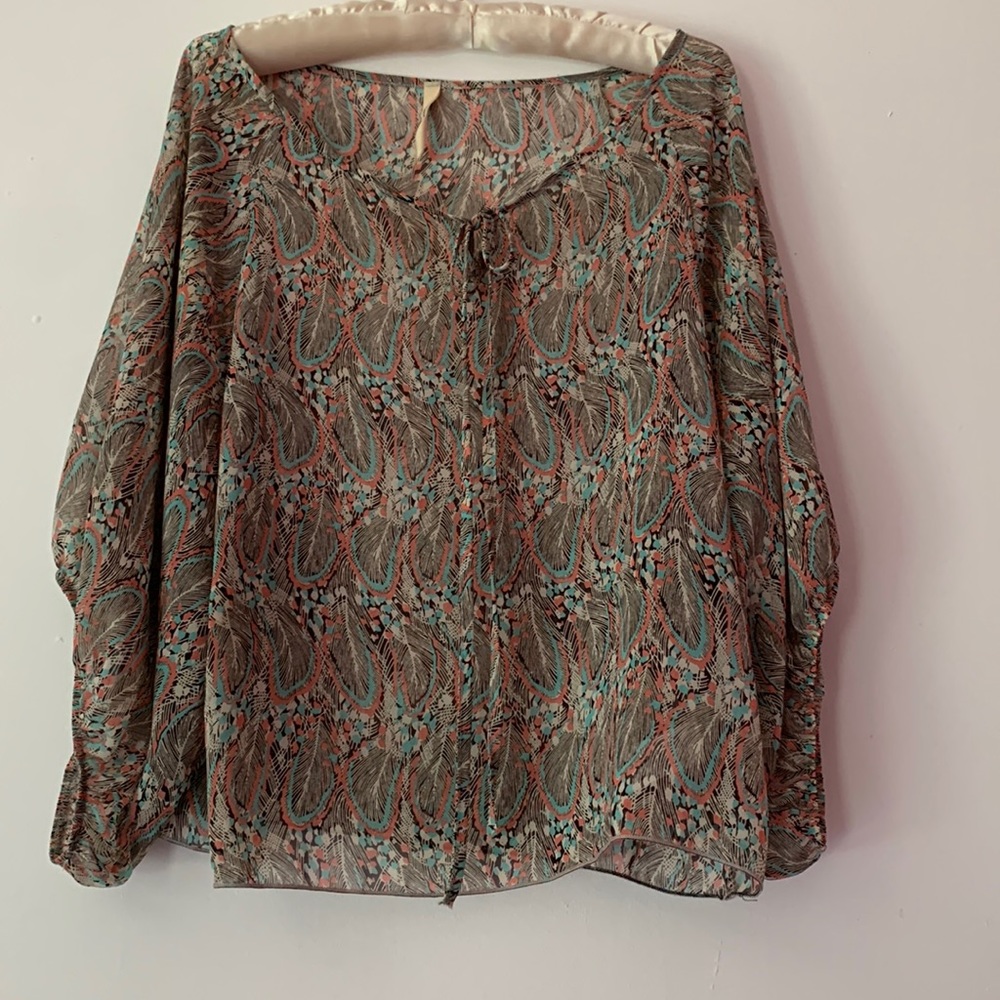 Fun top with dolman sleeves, a colorful feather print and front tie.